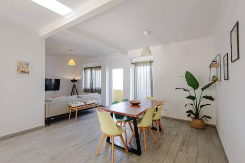 a living room with a table and yellow chairs at Sintra Sweet Apartments III - Free Parking in Sintra