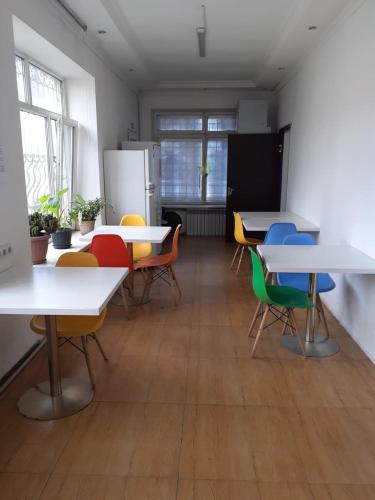 a room with tables and chairs and a refrigerator at Хостел in Almaty