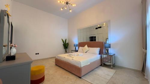 ein Schlafzimmer mit einem Bett, einem Tisch und einem Spiegel in der Unterkunft Dream 5BR Villa Escape - Near Corniche & Abu Dhabi City Center in Abu Dhabi