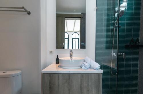 チャングーにあるGreenforest Anahata Villa Resortの洗面台と鏡付きシャワーを備えたバスルーム