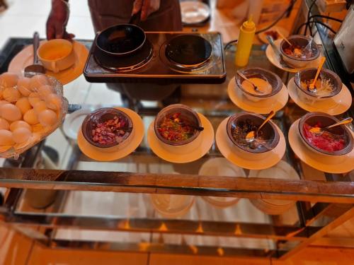 a tray of food on a table with plates of food at Sarwat Park Hotel Riyadh - Diplomatic Quarter in Riyadh