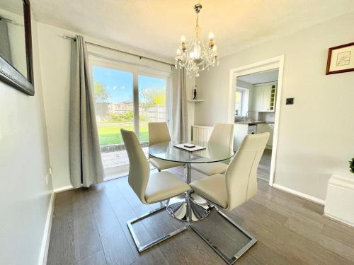 a dining room with a glass table and chairs at Haven lovely home just off M20 in great area & parking in Kent