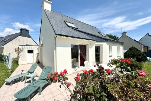 a house with two chairs on a patio at Charmante maison de vacances entre bourg et plages in Ploemeur