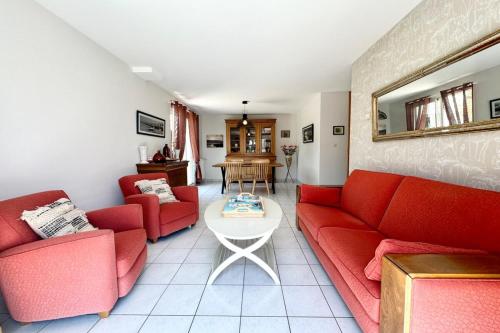 un salon avec des canapés rouges et une table dans l'établissement Charmante maison de vacances entre bourg et plages, à Ploemeur