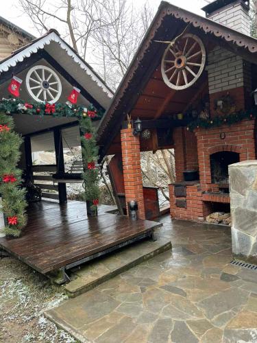 a house decorated for christmas with a wooden deck at Котедж в Карпатах in Huklyvyy