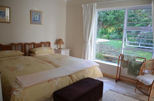 een slaapkamer met een bed en een groot raam bij Cherry Lane Constantia in Kaapstad