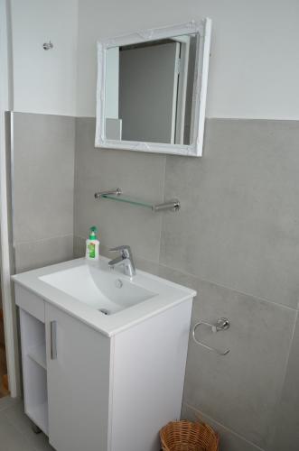 a bathroom with a white sink and a mirror at Cherry Lane Constantia in Cape Town
