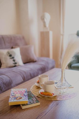 a coffee table with two cups and a book at Angelina Art in Trnava