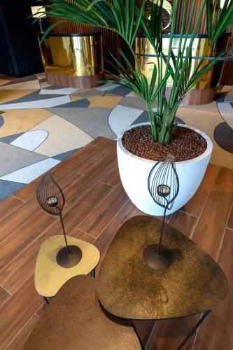 two tables and a potted plant in a room at Servotel Saint-Vincent in Nice