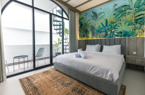 チャングーにあるGreenforest Anahata Villa Resortのベッドルーム1室(壁に絵画が描かれた大型ベッド1台付)