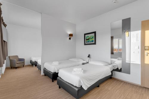 a hospital room with four beds and a chair at Hotel Vellir in Hafnarfjördur