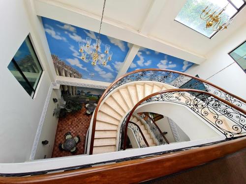 a spiral staircase with a mural of a sky at Hotel Castilla Real in Pereira