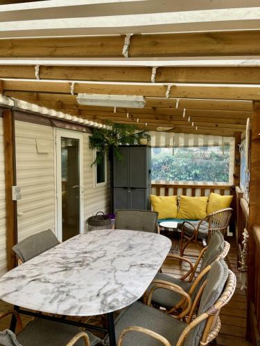d'une terrasse avec une table et des chaises en marbre. dans l'établissement Mobilhome BA281 - Small budget - Siblu Bonne Anse Plage, aux Mathes