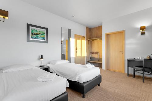a hotel room with two beds and a desk at Hotel Vellir in Hafnarfjördur