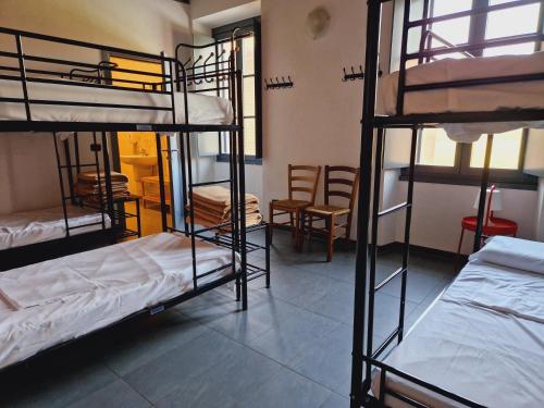 a room with several bunk beds and chairs at B&B e Ostello, Parco di Monza, CASCINA COSTA ALTA in Monza