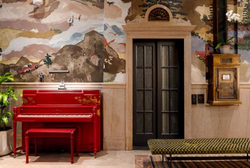 a red piano in a room next to a wall at The Flat Iron Hotel in Asheville