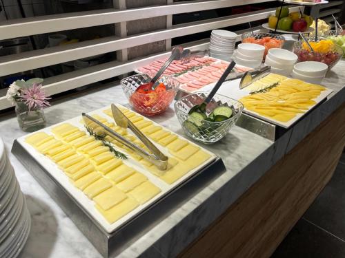 a buffet with cheese and other foods on a table at Anselmo Buenos Aires, Curio Collection by Hilton in Buenos Aires