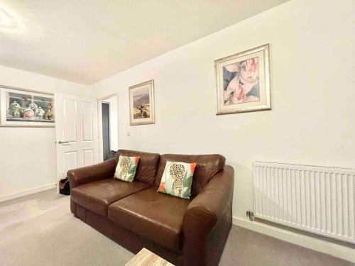 a living room with a brown leather couch at Hazel house new 4 bedroom home in Ashford in Ashford