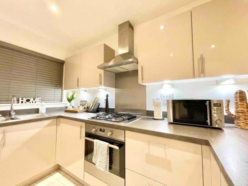 a kitchen with a microwave oven and a stove at Stay in comfort in this large 4 bedroom home in Ashford! in Ashford