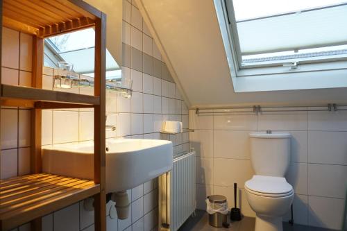 a bathroom with a sink and a toilet and a skylight at Kustverhuur, Vakantiepark Fort Soleil 43 in Breskens