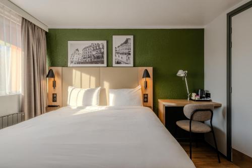 a bedroom with a bed and a desk and a chair at Campanile NATURE - Lille Est Villeneuve-d'Ascq in Villeneuve d'Ascq