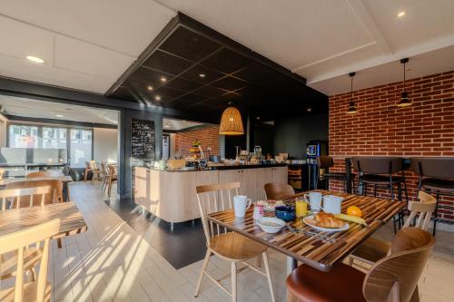 ヴィルヌーヴ・ダスクにあるCampanile NATURE - Lille Est Villeneuve-d'Ascqの食べ物が置かれたテーブルがあるレストラン