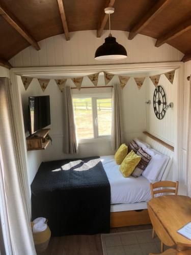 a bedroom with a bed with a window and a table at Back in Thyme in Colchester