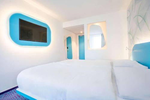 a bedroom with a large bed and a flat screen tv at Prize by Radisson, Hamburg St Pauli in Hamburg