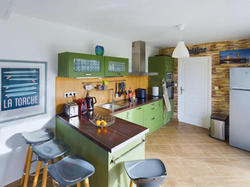 une cuisine avec des placards verts et des tabourets de bar dans l'établissement À 300m de la côte sauvage, maison familiale pour 8, à Penmarcʼh