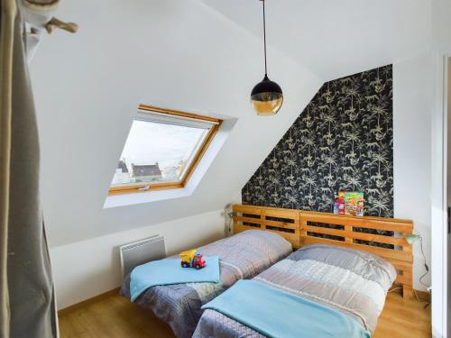 une chambre avec deux lits et une fenêtre dans l'établissement À 300m de la côte sauvage, maison familiale pour 8, à Penmarcʼh
