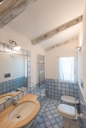 a bathroom with a sink and a toilet and a mirror at Villa Mimosa in Golfo Aranci