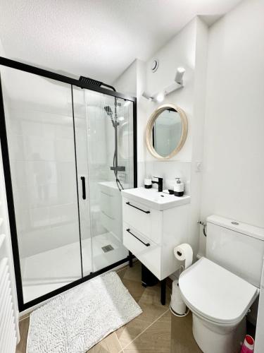 une salle de bain blanche avec douche et toilettes dans l'établissement Sublime T2 refait à neuf - Vue mer 180 - Piscine, à Guidel