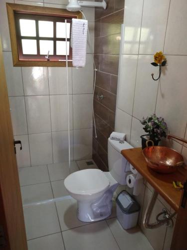 a small bathroom with a toilet and a sink at Chalé Quiririm in Santo Antônio do Pinhal