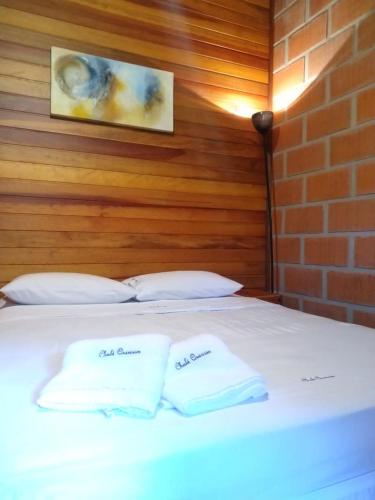a bedroom with a bed with two towels on it at Chalé Quiririm in Santo Antônio do Pinhal