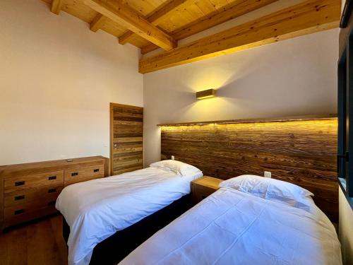 deux lits dans une chambre avec plafonds en bois dans l'établissement Grand T3 et Coin montagne central et lumineux - Multipass inclu, à Châtel