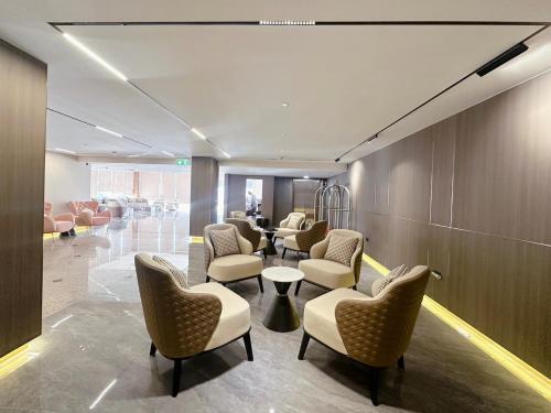 a waiting room with chairs and tables in a building at Miloft Suvarnabhumi Airport Hotel in Bangkok