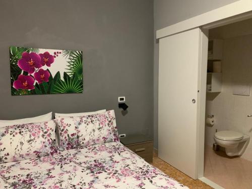 una camera da letto con un letto con fiori rosa di B&B Residence Armonia Sulmona a Sulmona
