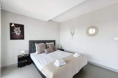 a bedroom with a large bed with white walls at Elegant Design Apt With Balcony And Pool in Porto-Vecchio