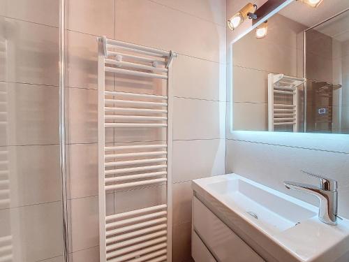 une salle de bain blanche avec un lavabo et un miroir dans l'établissement Christiana 5, à Saint-Jean-dʼAulps