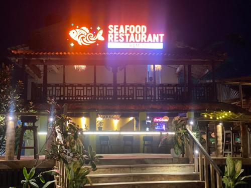 a restaurant with a neon sign at night at Villa Amorino in Galle