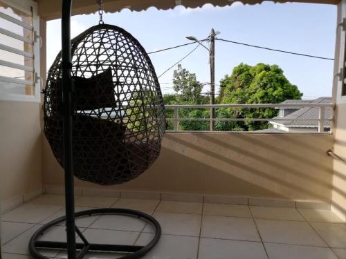 a bird cage sitting on a balcony with a view at Lahaut in Sainte-Rose