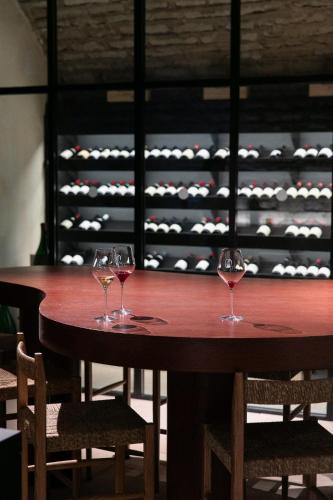 two wine glasses sitting on a wooden table in a wine cellar at Bellevigne Bourgogne in Chambolle-Musigny
