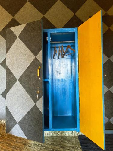a blue door with pairs of shoes on a wall at Samyama Retreat in Cola