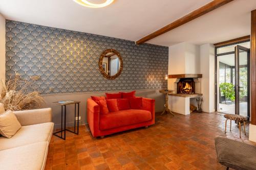 un salon avec une chaise rouge et une cheminée dans l'établissement 