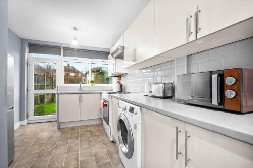 a kitchen with a washer and dryer in it at Stylish 3 Bedroom House - Parking - Garden - Great Barr - Netflix - Top Rated -121J in Birmingham