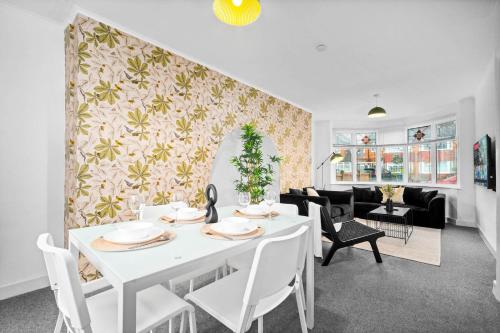 a white dining room with a white table and chairs at Stylish 3 Bedroom House - Parking - Garden - Great Barr - Netflix - Top Rated -121J in Birmingham