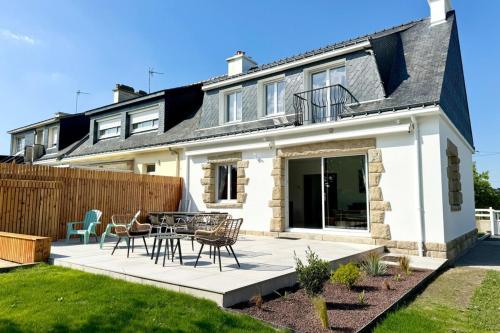 une maison avec un patio avec des chaises et une table dans l'établissement Maison rénovée de standing - 100m des plages, à Ploemeur
