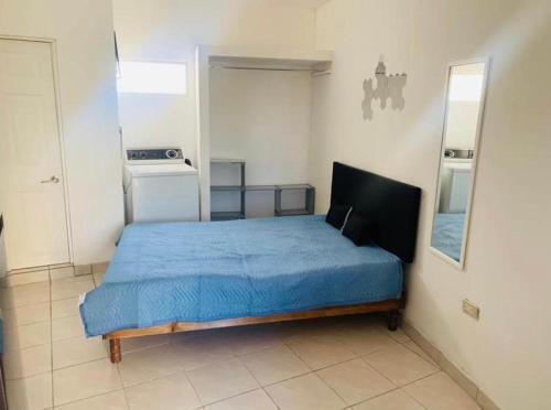 een slaapkamer met een blauw bed in een kamer bij Apartamento Las Aldabas in Chihuahua