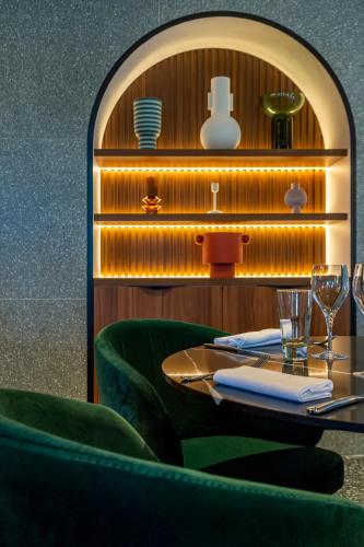 a table in a restaurant with green chairs at Servotel Saint-Vincent in Nice