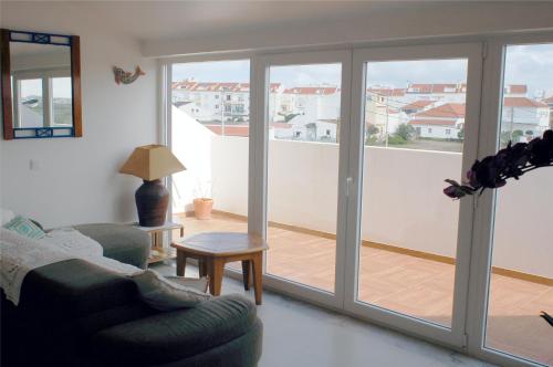 a living room with a couch and a sliding glass door at Hotel Baleal Spot in Baleal